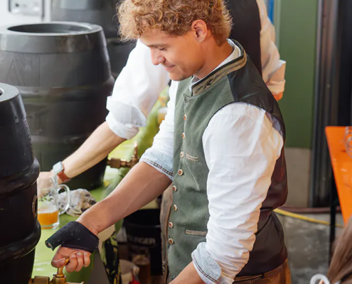 Bierausschank Zapfer im Trachtengewand schenkt Zoiglbier aus Fass in Maßkrug beim Fest ein