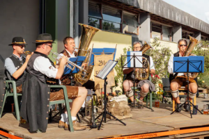 Blaskapelle in Tracht spielt auf einer Bühne beim Zoiglbierfest am Piehlerhof.