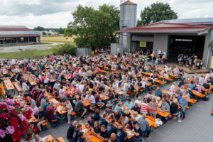 Überblick über vollen Festhof mit langen Tischreihen und vielen Gästen beim Zoiglbierfest.