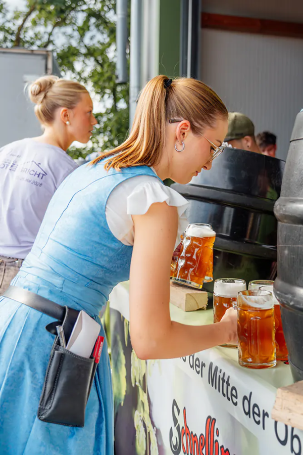 Nachschub holen Bedienung im blauen Dirndl holt frisch gezapfte Zoiglbier-Krüge von der Theke.