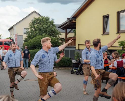 Plattler Männer in Lederhosen führen traditionellen Plattler-Tanz auf dem Hof des Zoiglbierfests auf.