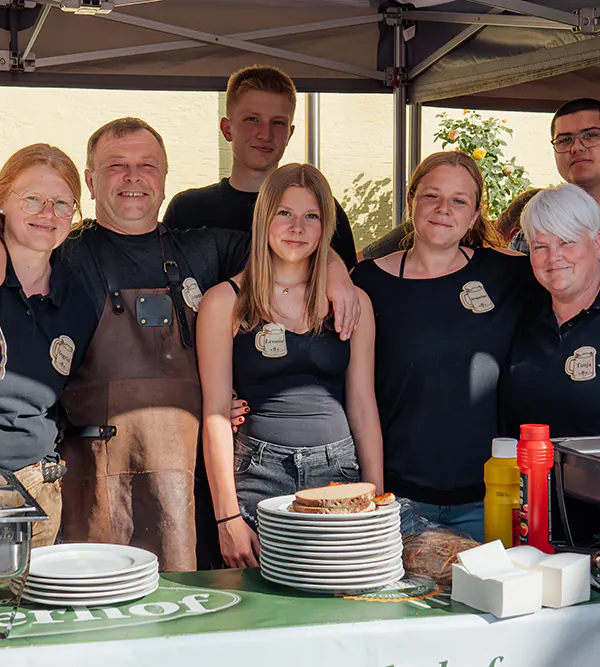 Verkostungsteam Ein Teil des Teams vom Piehlerhof steht lächelnd hinter der Brotzeit-Theke beim Zoiglbierfest.