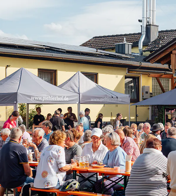 Voller Hof Volle Bierbänke mit Gästen vor den Piehlerhof-Zelten beim Zoiglbierfest im Hof.